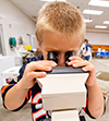 child looking through microscope at College of Vet Med at Illinois Open House