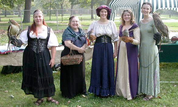 Rose Ann Meccoli poses with veterinary students at a medieval fair with the resident birds of prey
