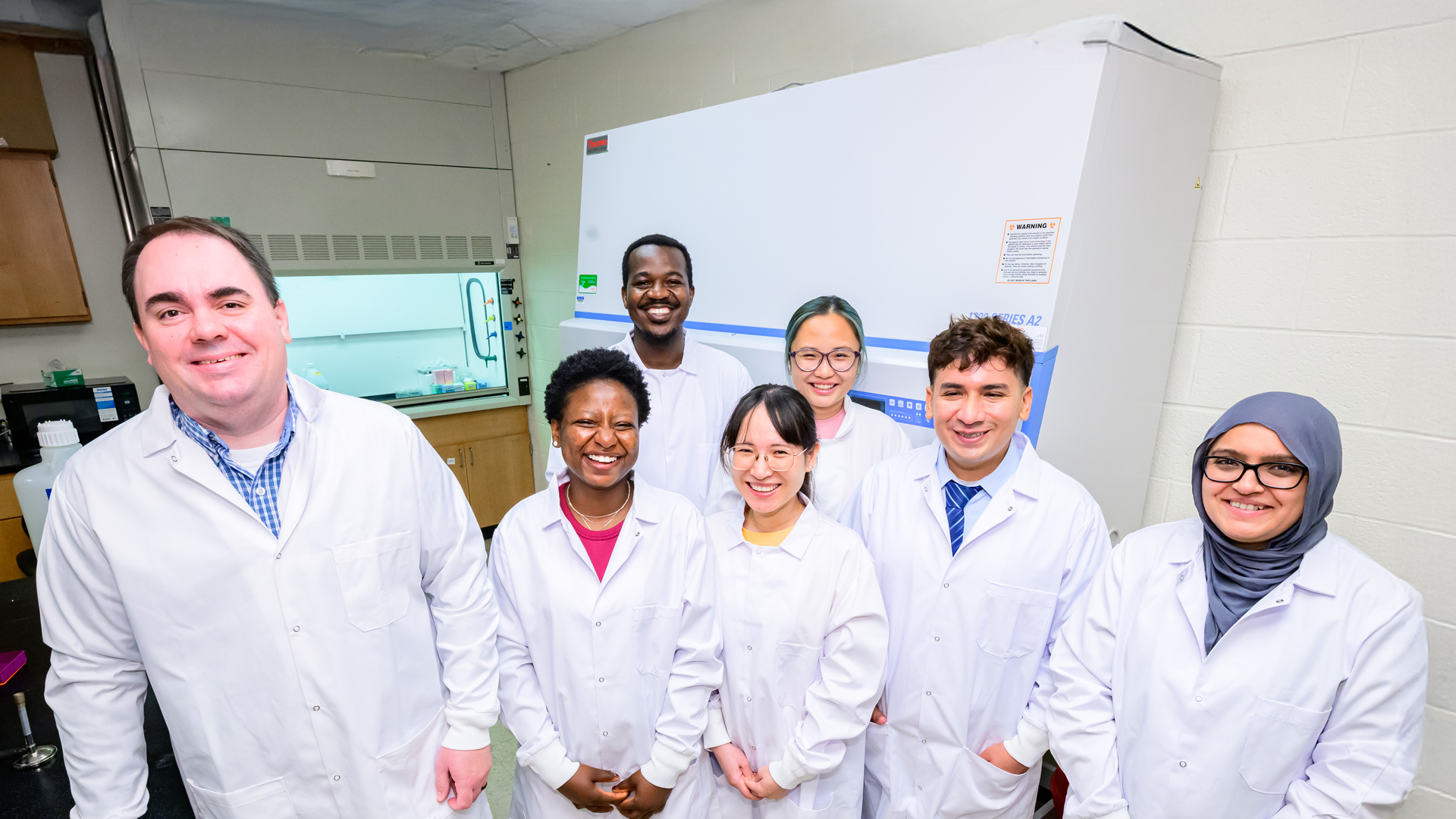 Dr. Christopher Gaulke, an professor in the Department of Pathobiology, works with his research team at the College of Veterinary Medicine.
