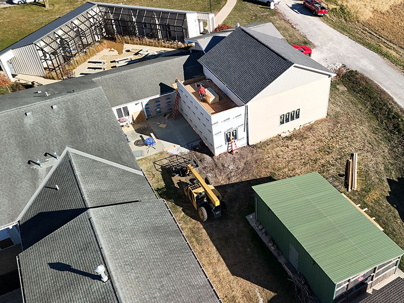 Aerial view of the Wildlife Medical Clinic Education Center expansion at the University of Illinois College of Veterinary Medicine. The photo shows the new addition connected to the existing building, with construction equipment and materials on site.
