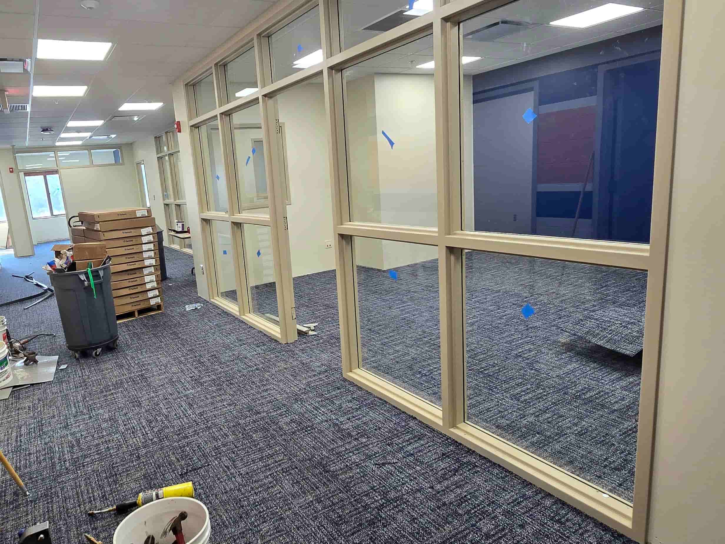 Academic Student Affairs remodel area with new carpet, glass office partitions, and construction materials in a hallway.