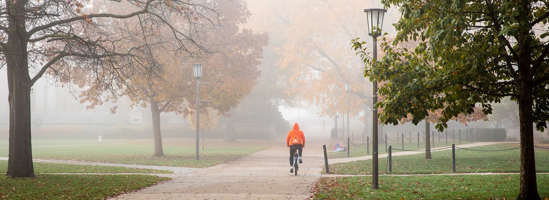 Student riding bicycle on campus.