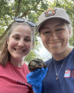Kami and Dr. Kaitlin cheesing with a musk turtle