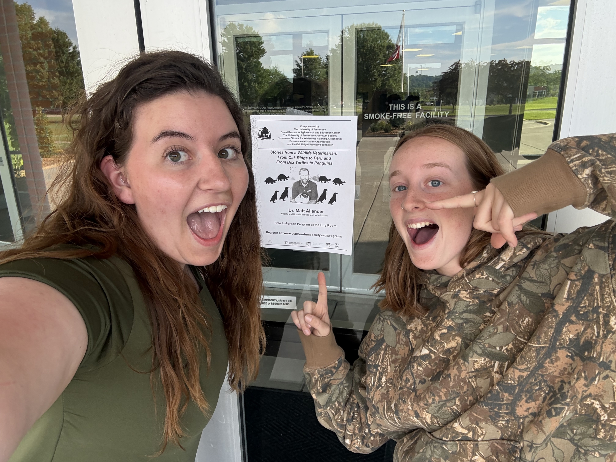 Becca and Grace pointing at Allender's future presentation poster