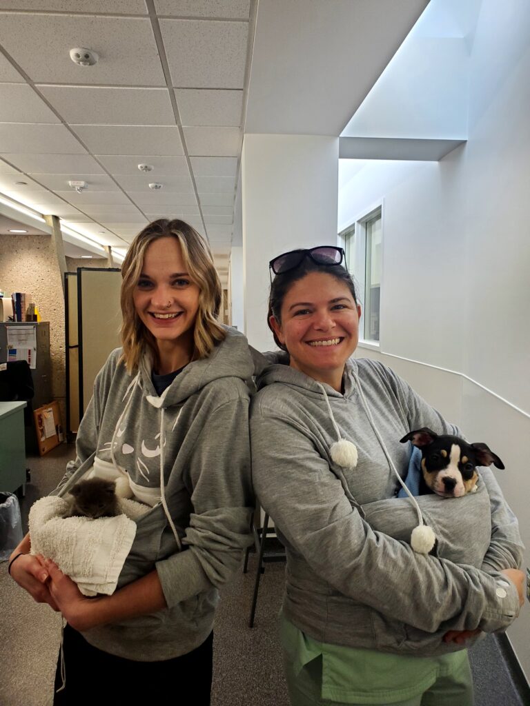 Rachel Dorney and her friend holding dogs.