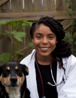 Dr. Chandler Carter poses next to a Rottweiler patient