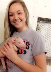 [Brandi Burton with a piglet]