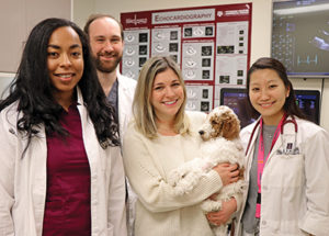 Cardiology Residents (from left) Drs. Gabrielle Wallace, Jon Stack, and Saki Kadotani with vet student whose puppy needed a PDA
