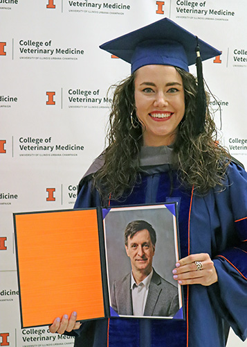 [Dr. Sophia Ochs holds photo of Dr. Ian Sprandel]