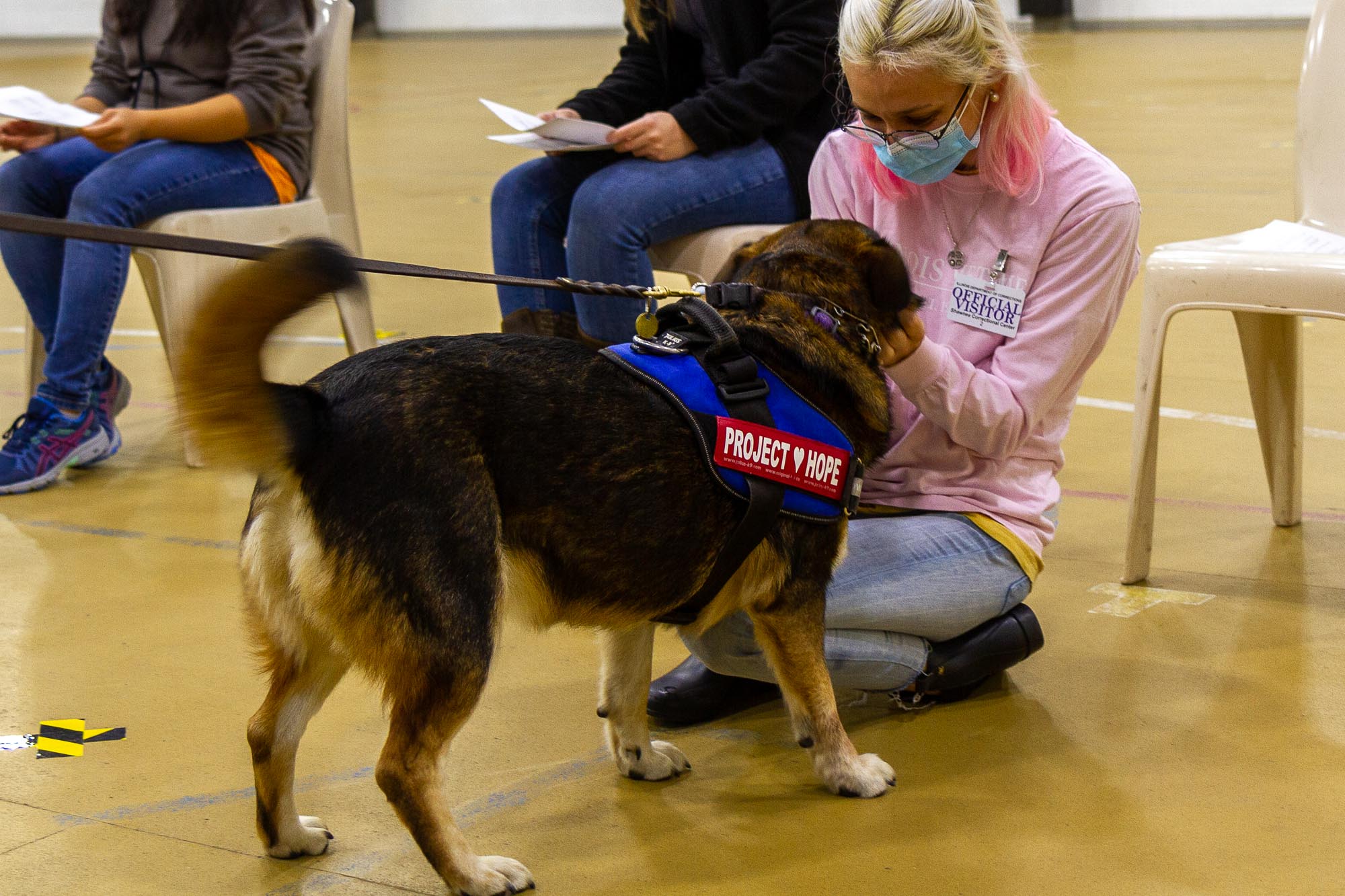 [Dria Talley greets a dog in the training program]