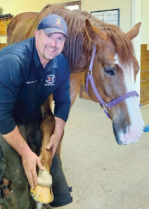 Tobais Ellis works on the hoof of a horse