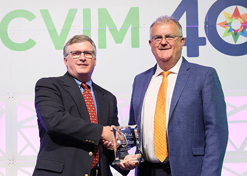 Peter Constable accepts award from ACVIM Immediate Past Chair Dr. Harold McKenzie