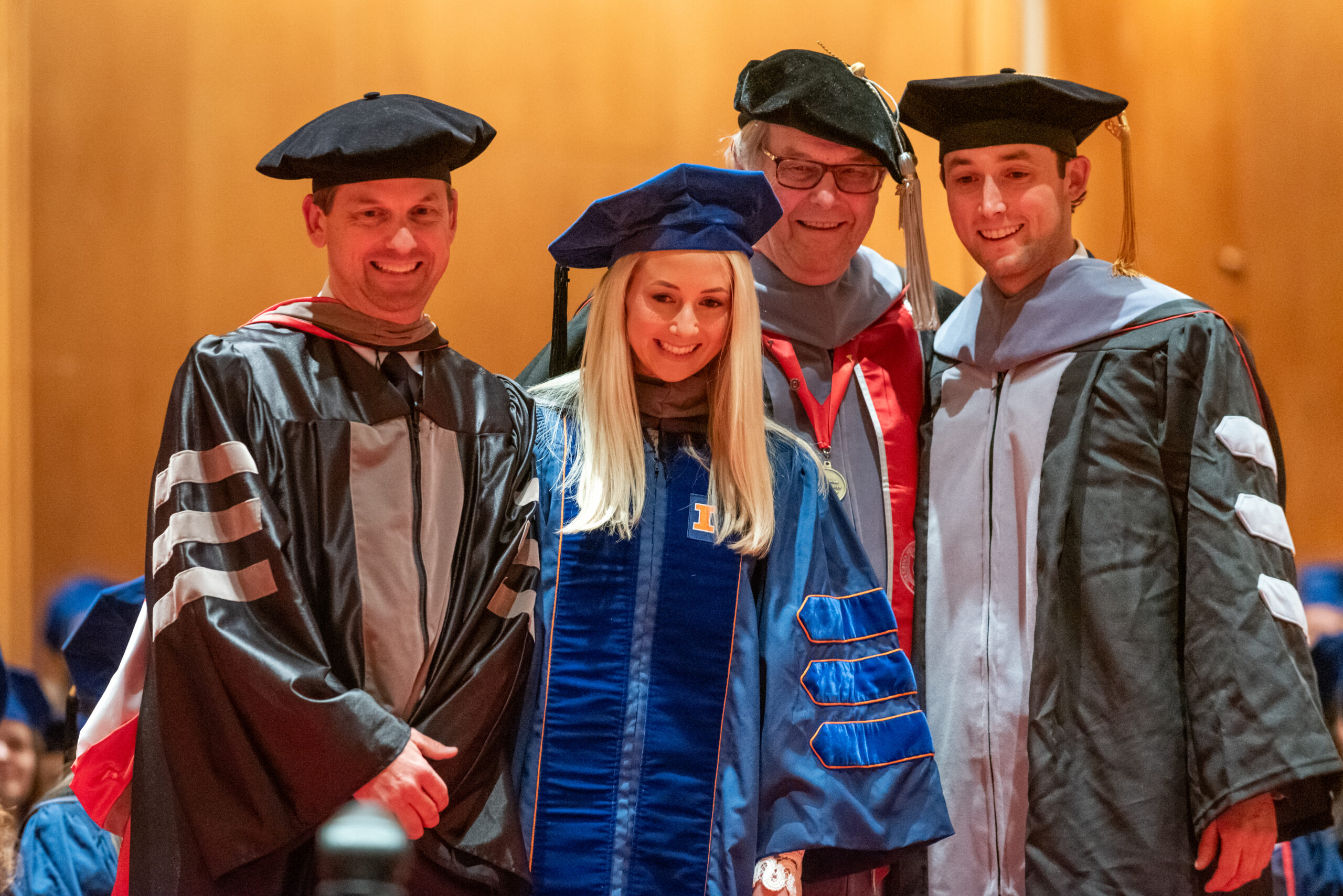 Class of 2024 DVM graduate, Dr. Grace Steinman, with veterinarian father, grandfather, and brother during the convocation ceremony.