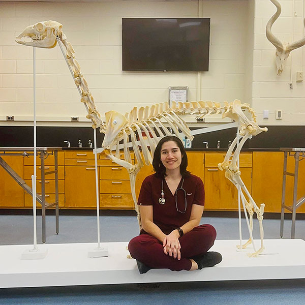 Crystal Munguia poses with the llama skeleton she built by herself.