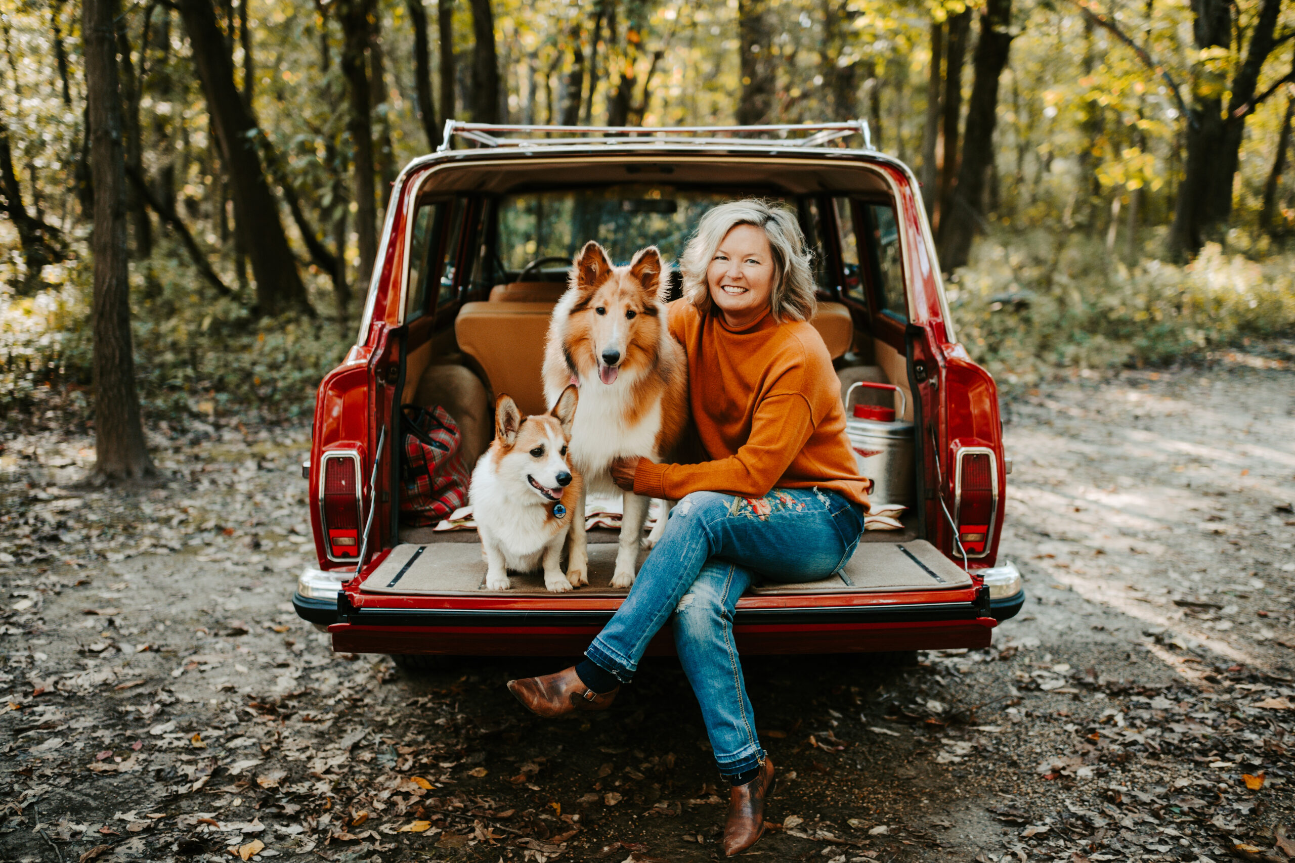 Ginger Passalacqua and her two dogs in the back of a red car.