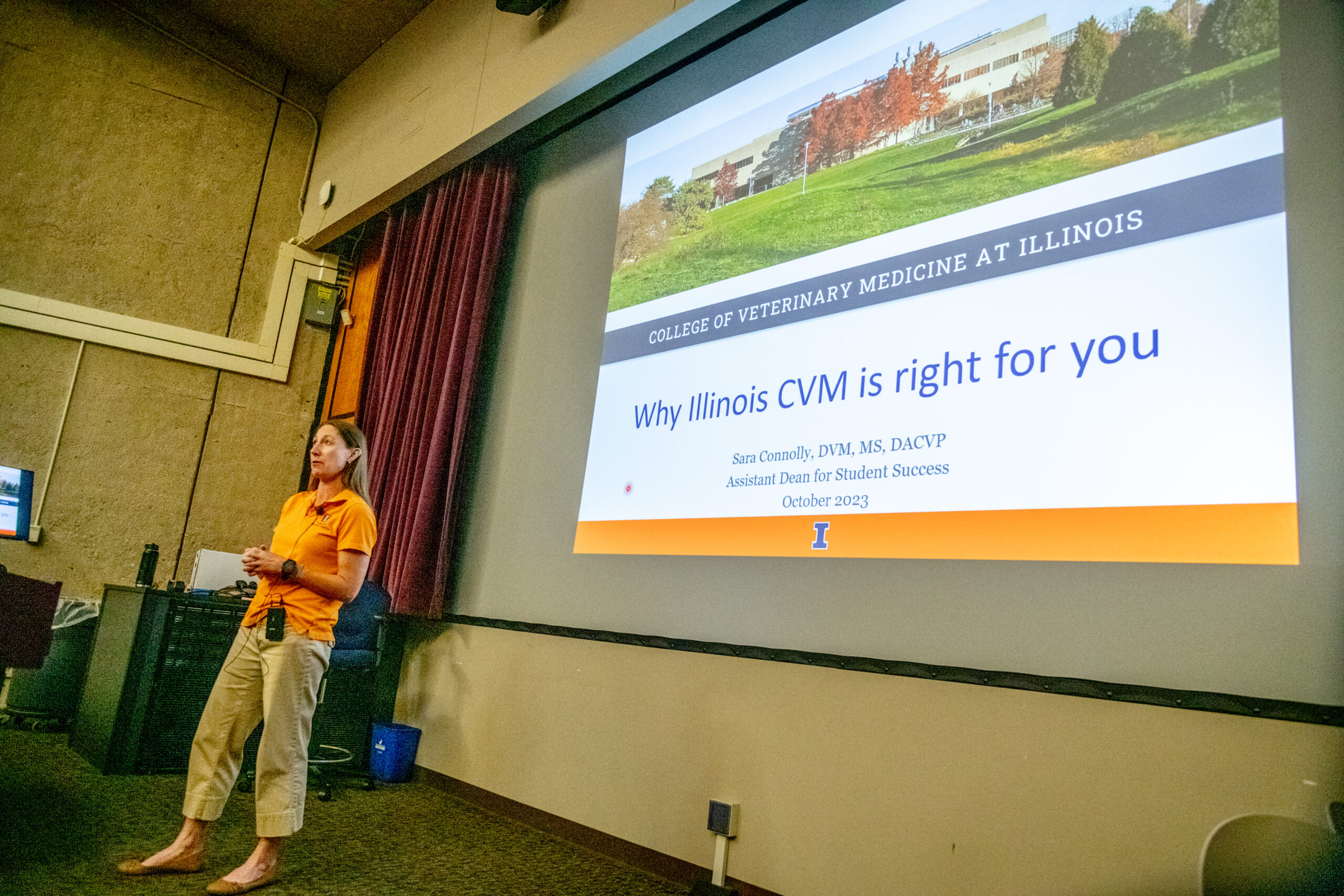 Dr. Sara Connolly stands in front of a slideshow she's presenting about why the University of Illinois Urbana-Champaign's College of Veterinary Medicine is right for prospective students.