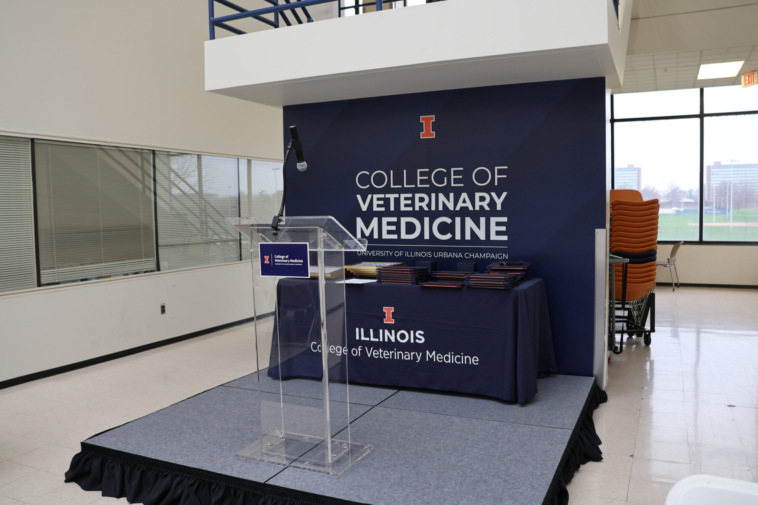 A picture of a stage set up in the atrium of the Basic Sciences Building with a College of Veterinary Medicine backdrop.