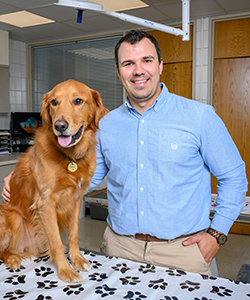 Dr. Todd Marlo posing with a golden retriever