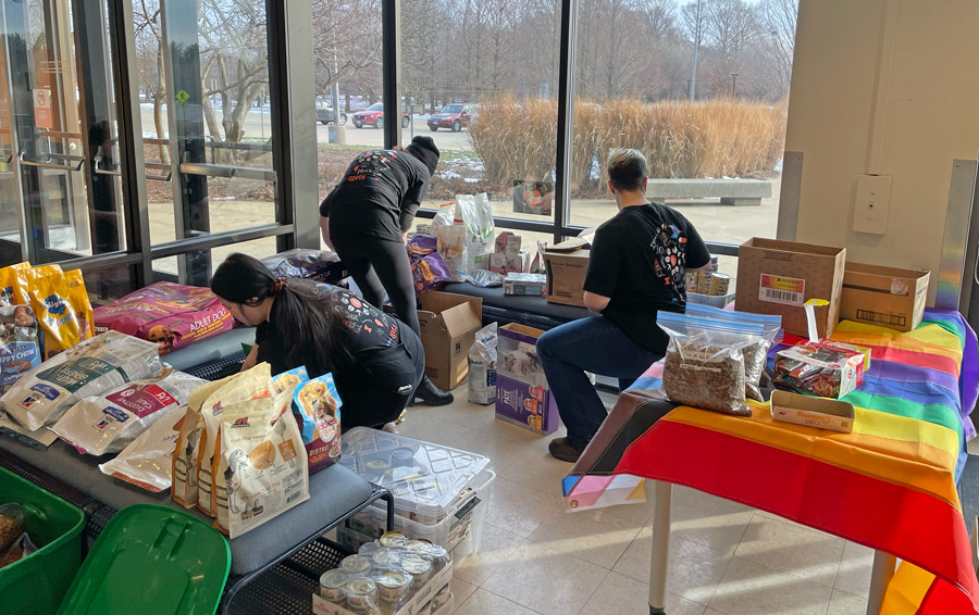 Members of the Illinois VOICE chapter packing boxes with nonperishable dog food at their pet pantry outreach event as a part of the 2025 national conference.