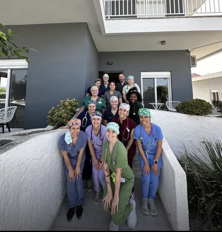 A group of veterinary students in scrubs posing for a photo.