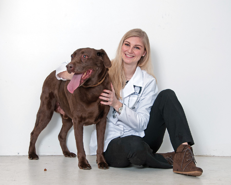 Dr. Alyssa Baratta-Martin sitting with a brown dog.