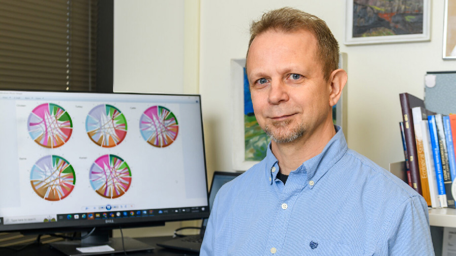 Dr. Csaba Varga stands in his office