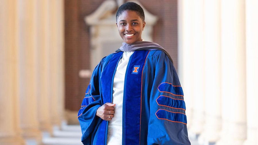 OC Kirkland posing in her graduation gown at Memorial Stadium.