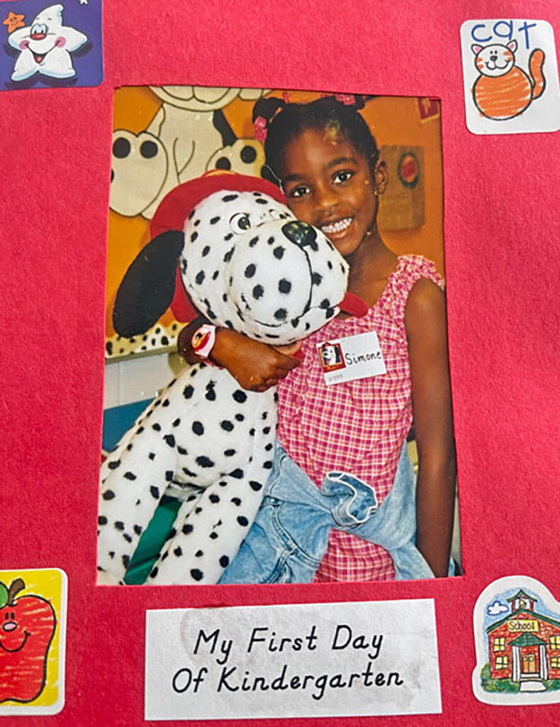OC Kirkland smiling with a white dalmatian stuffed animal on her first day of kindergarten.
