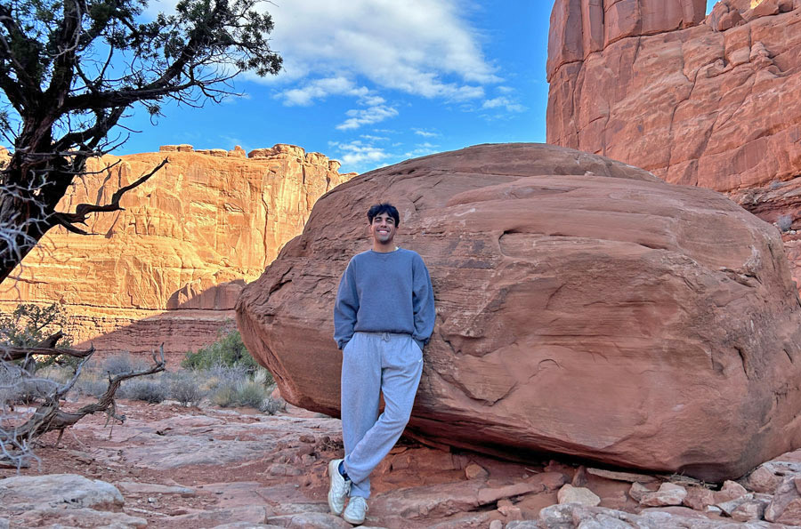 Varun Seth posing in front of a large boulder.