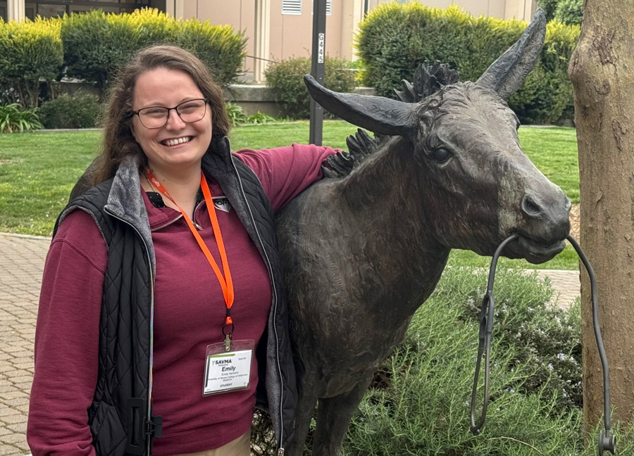 Emily Verwers next to a donkey statue.