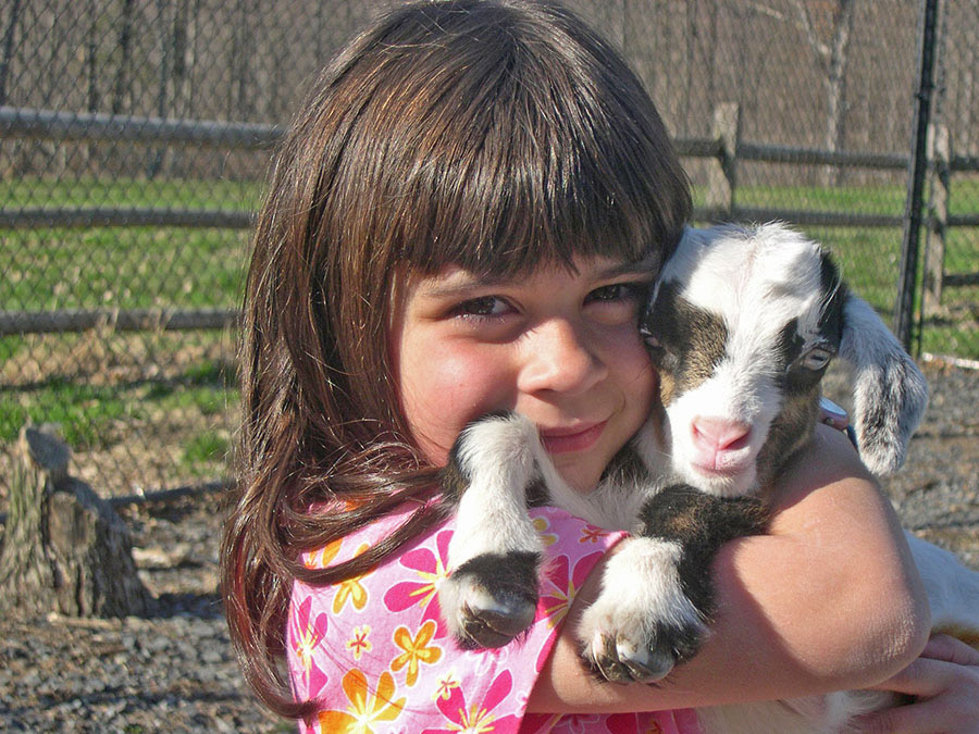 Hannah Streams as a little girl holding a baby goat.