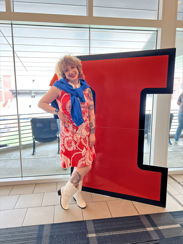 Kristine Witte posing in front of the "Block I," the current logo for the University of Illinois Urbana-Champaign.