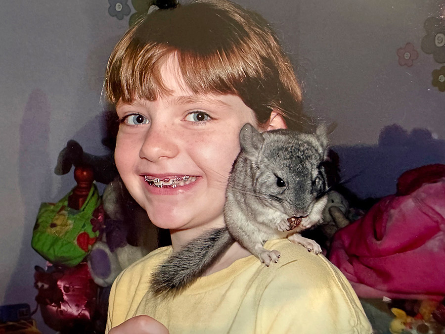 A child with a chinchilla on their shoulder.