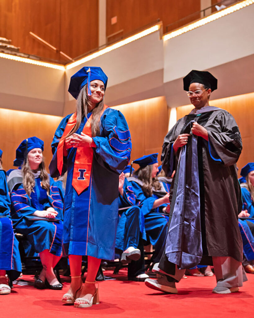Naomi Esquivel being hooded at the College of Veterinary Medicine graduation ceremony by Dr. Yvette Johnson-Walker.