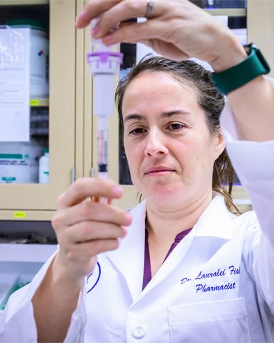 Veterinary pharmacist Dr. Lauralei Fisher-Cronkhite measuring a dose of medication