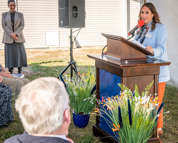 Christine Dietrich at the podium speaking to Dr. John Coyne