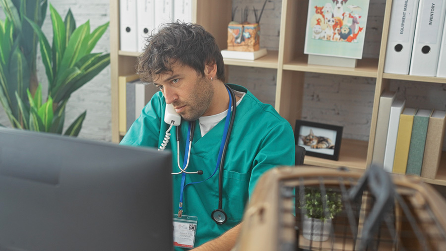 A medical worker at a desk on the phone.