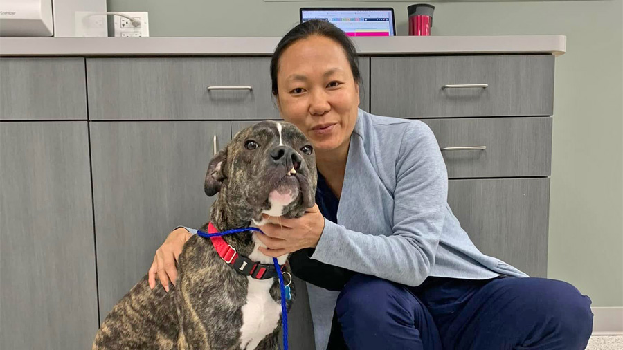 Dr. Jessica Von Waldau in a vet clinic hugging a dog