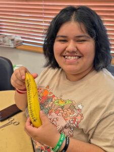 Wet lab participant shows her sutured banana